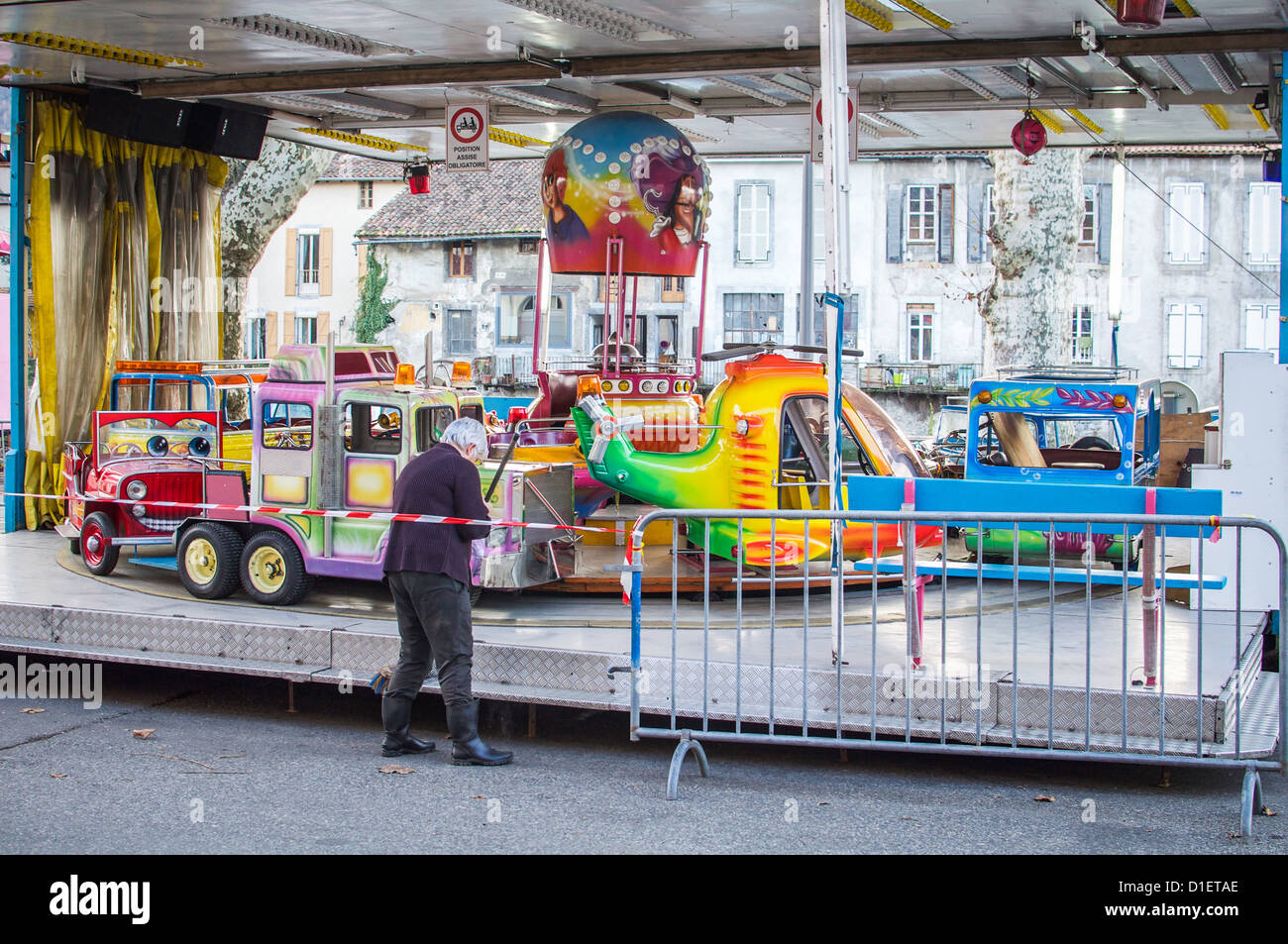 Woman sweeping the metal étapes d'un carnival ride à St Girons, France. Banque D'Images