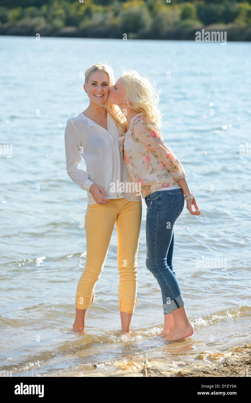 Deux jeunes femmes blondes s'embrasser au lac de baignade Banque D'Images