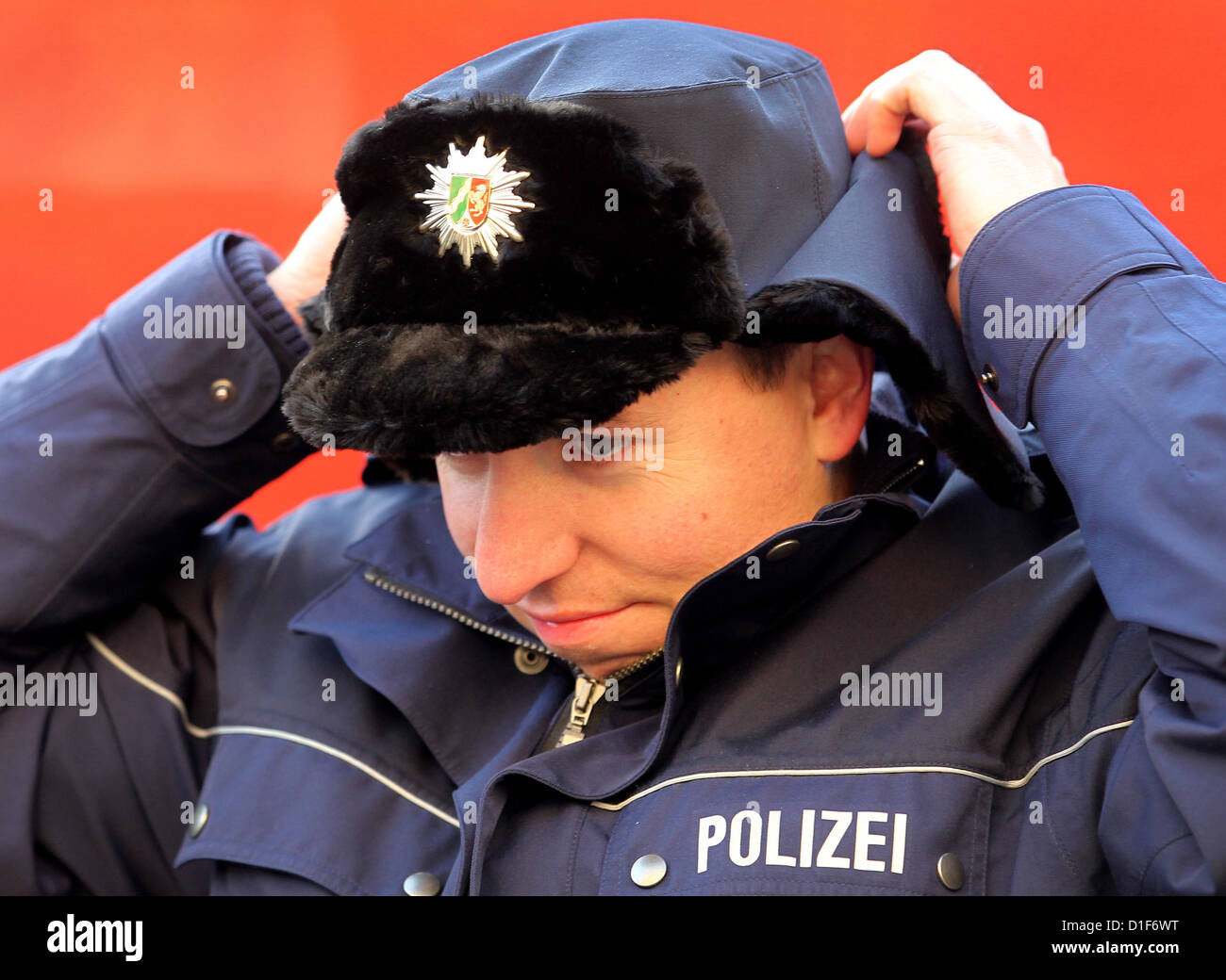 (Afp) - Une archive photo, datée du 30 novembre 2011, spectacles policier Marco Spelleken la mise sur un chapeau d'hiver à Duesseldorf, Allemagne. L'offre de standard de police émis caps d'hiver à des agents de police a été arrêté en raison d'un manque de qualité et de fabrication défectueux. Photo : Roland Weihrauch Banque D'Images