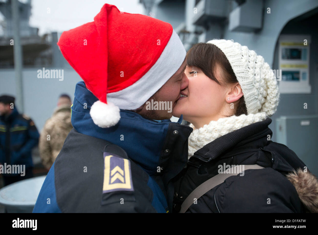 Un membre d'équipage de la corvette 'Magdeburg' embrasse sa petite amie qu'il revient de mission au Liban il Rostock-Hohe Duene, Allemagne, 19 décembre 2012. Le 58 marines américains étaient stationnés à la côte libanaise pendant trois mois. Photo : JENS BUETTNER Banque D'Images