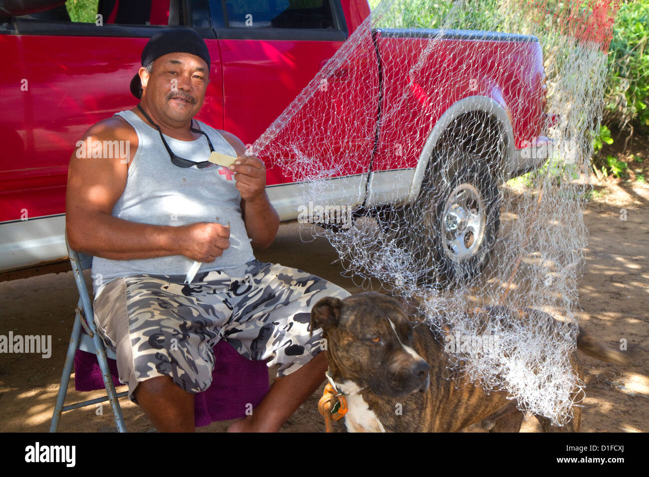 Native hawaiian pêcheur réparant un filet sur l'île de Kauai, Hawaii, USA. M. Banque D'Images