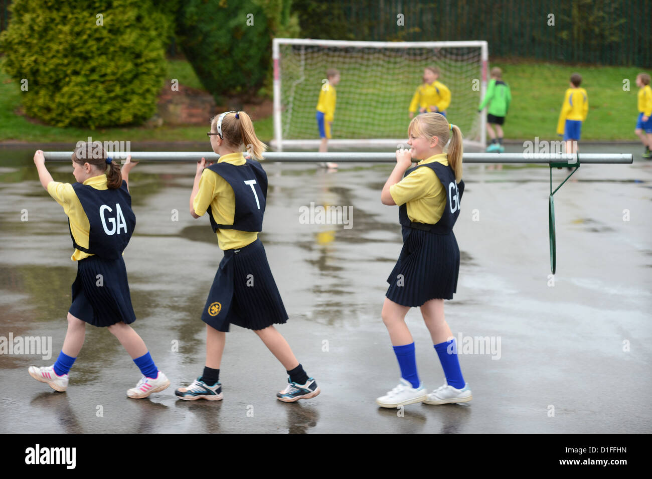 Les écoliers portant un objectif de netball à Notre Dame et St Werburgh's Catholic Primary School à Newcastle-under-Lyme, Staffordshi Banque D'Images