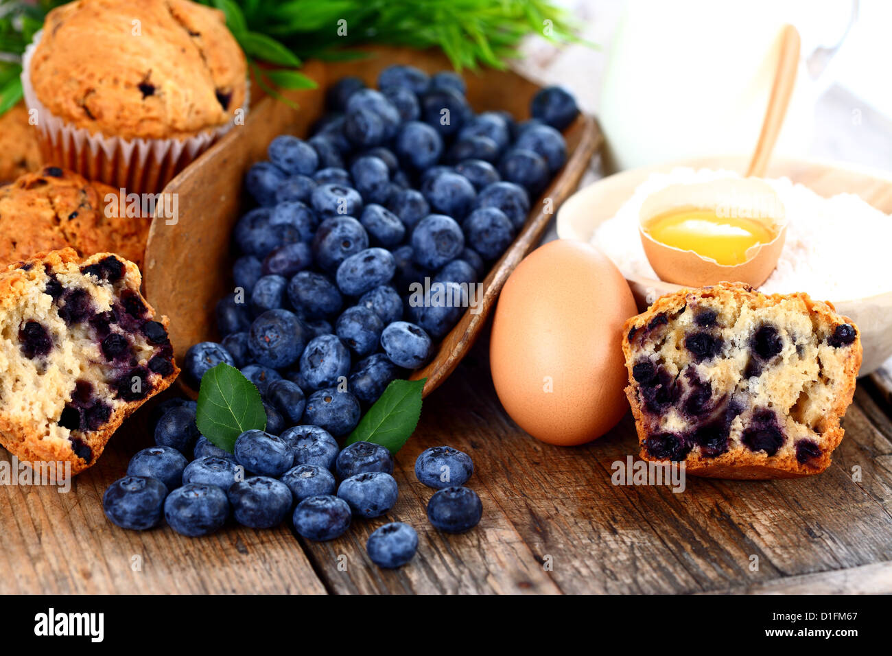 Muffins aux bleuets, d'œuf et la farine sur la table en bois Banque D'Images