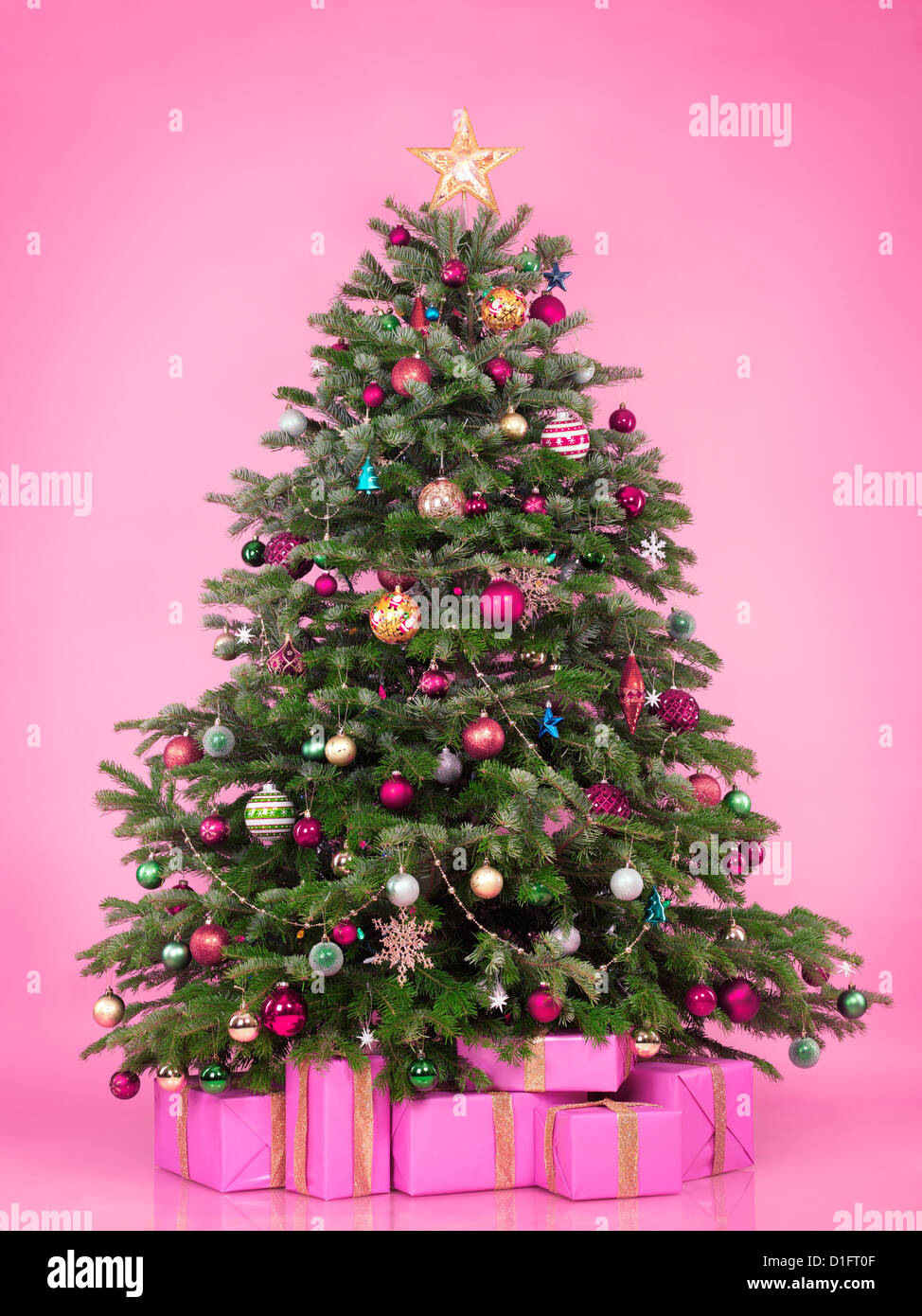Arbre de Noël décoré avec des cadeaux et coffrets cadeaux isolé sur fond rose Banque D'Images