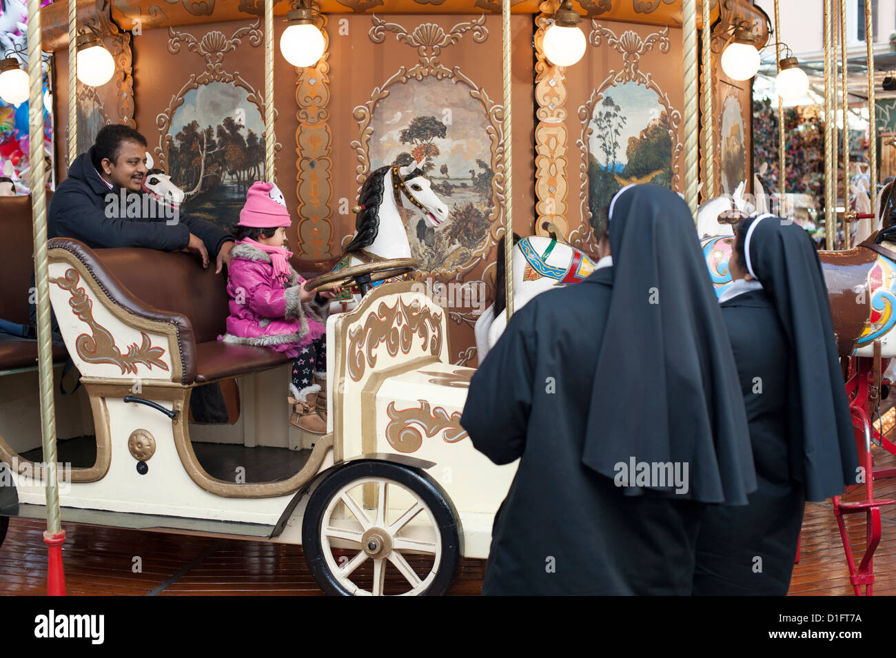 Les nonnes chercher jeune fille dans le carrousel Banque D'Images