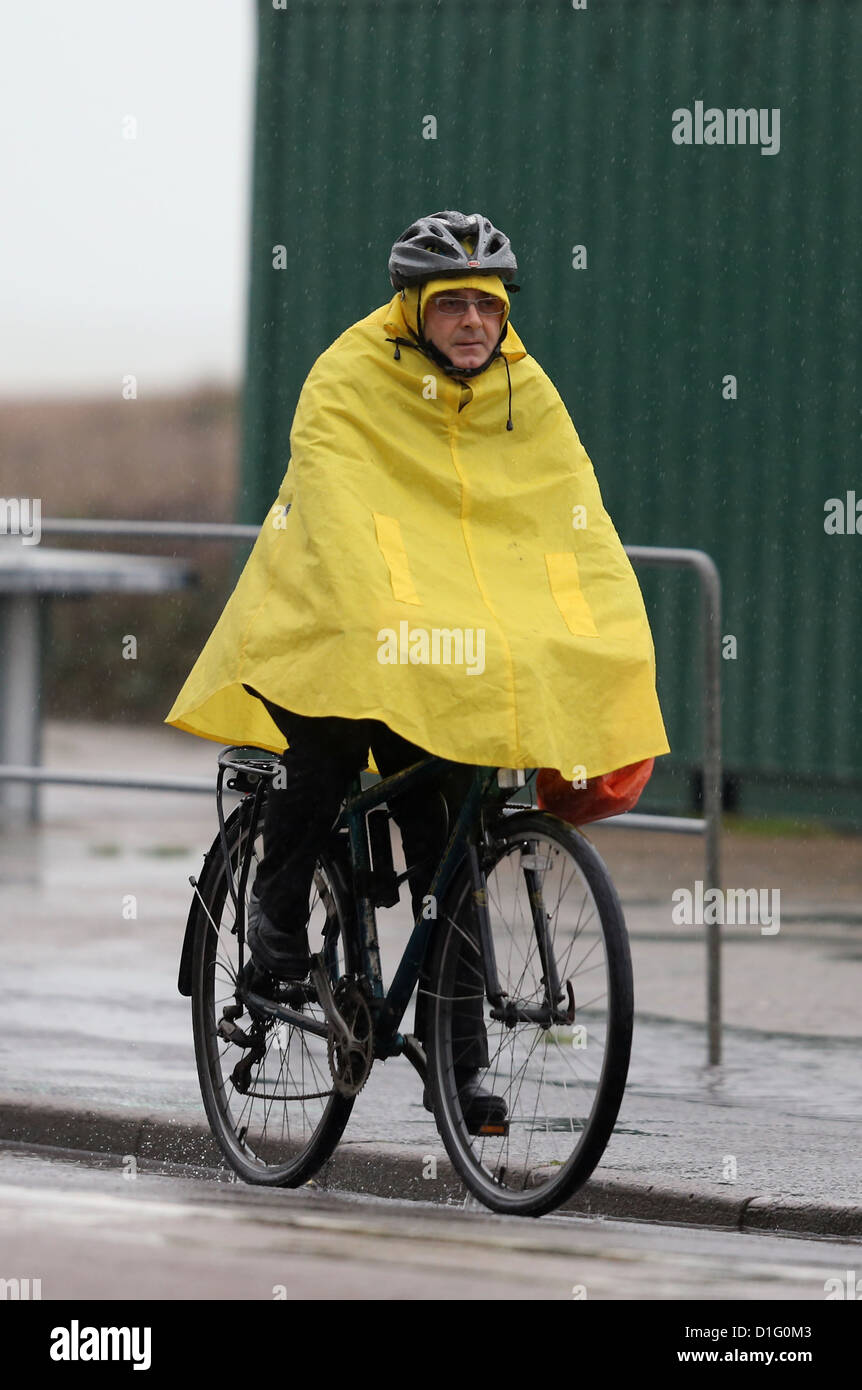 Un cycliste dans un poncho jaune vif le long de cycles de front de mer de Brighton sous la pluie battante. Photo par James Boardman Banque D'Images