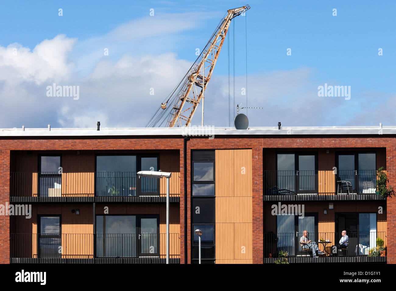 Deux hommes assis sur un balcon à la nouvelle construction de maisons sur Govan Road, Glasgow Banque D'Images