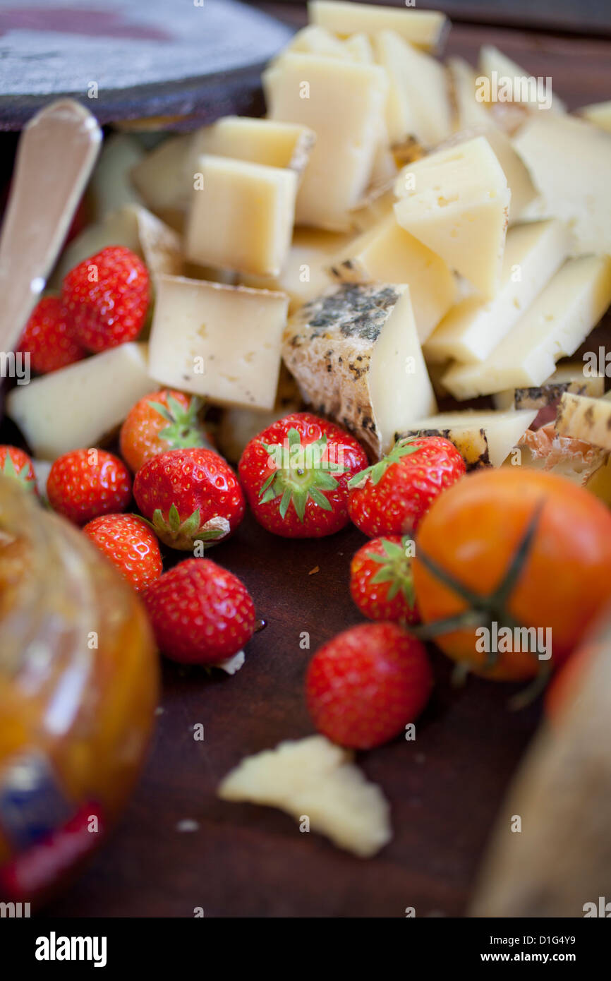 Des cubes de fromage, fraises, tomates, miel Banque D'Images