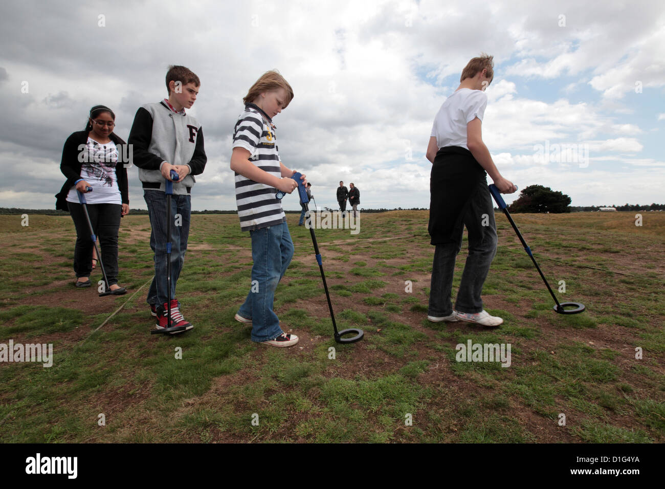 Groupe d'enfants à l'aide de détecteurs de métaux sur field hill, Sutton Hoo, Suffolk, UK Banque D'Images