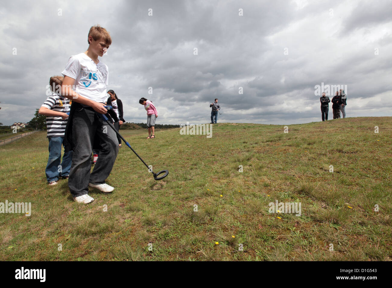 Groupe d'enfants à l'aide de détecteurs de métaux sur field hill, Sutton Hoo, Suffolk, UK Banque D'Images