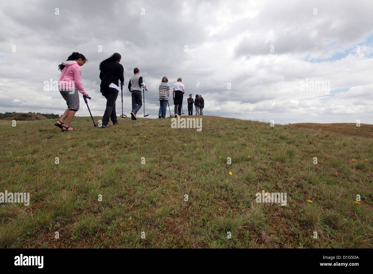 Groupe d'enfants à l'aide de détecteurs de métaux sur field hill, Sutton Hoo, Suffolk, UK Banque D'Images