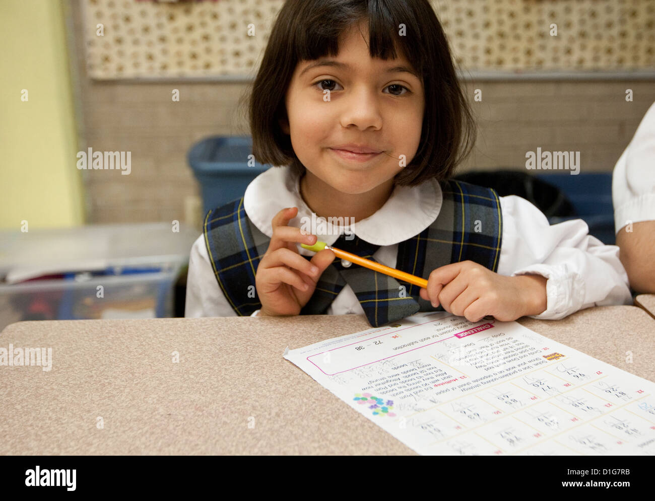 Smiling Hispanic deuxième grade elementary school girl en uniforme en classe à l'école privée catholique au Texas Banque D'Images