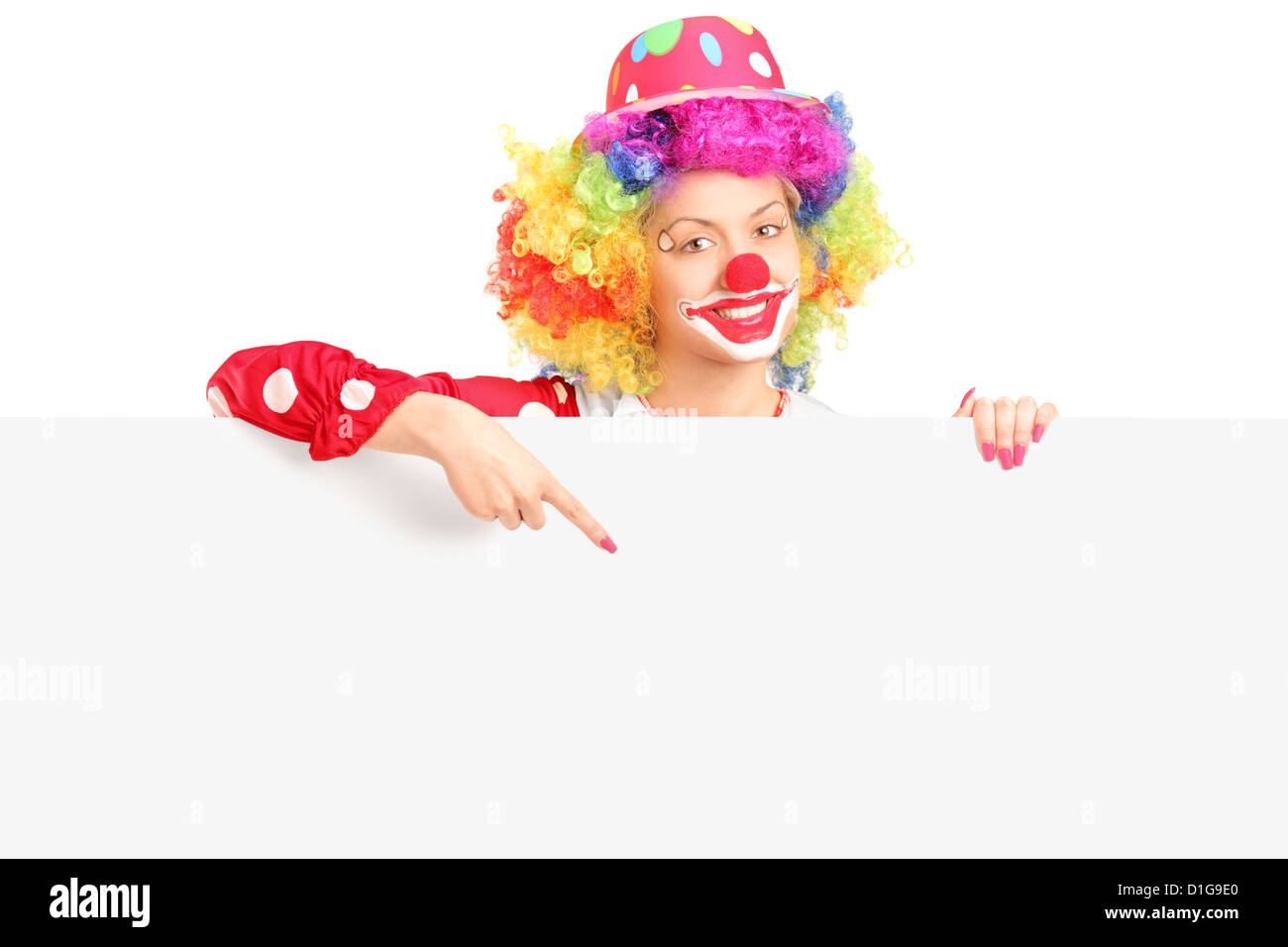 Avec happy clown femelle expression joyeuse pointant avec le doigt sur un panneau vide isolé sur fond blanc Banque D'Images