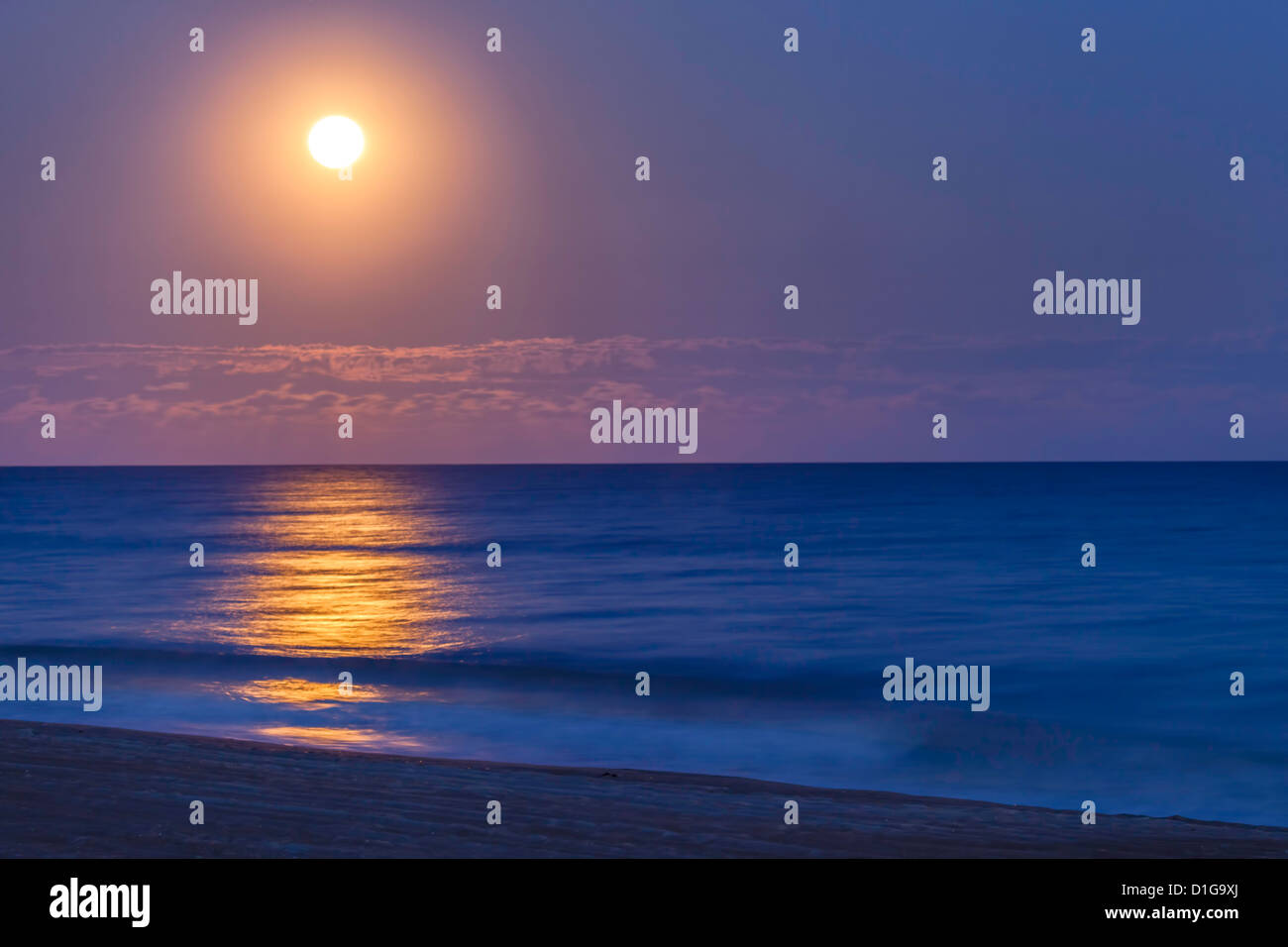 La pleine lune se lève au-dessus de l'océan Atlantique et la plage de l'île d'Émeraude en Caroline du Nord. Banque D'Images
