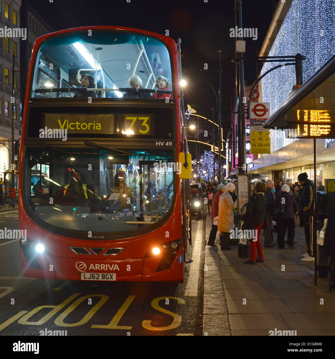 London Double Decker à l'arrêt de bus à l'extérieur du magasin d'Oxford Street la nuit de Noël Banque D'Images