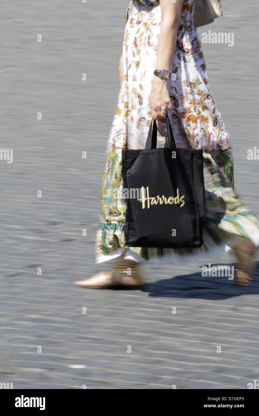 Femme marche avec harrods sac shopping en street road Photo Stock - Alamy