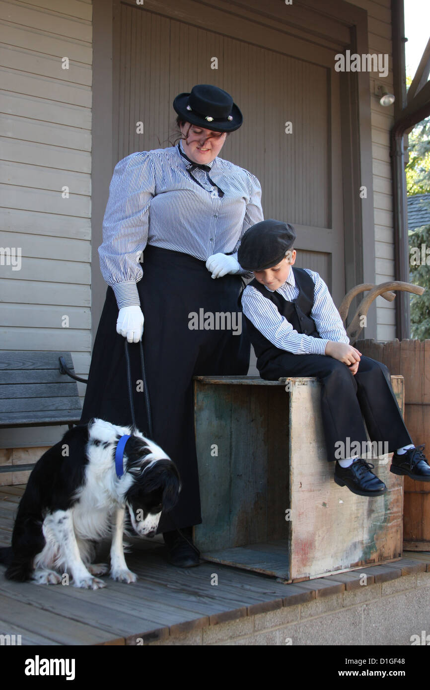 Une femme, un chien et un enfant en attente sur une plate-forme de train depot Banque D'Images