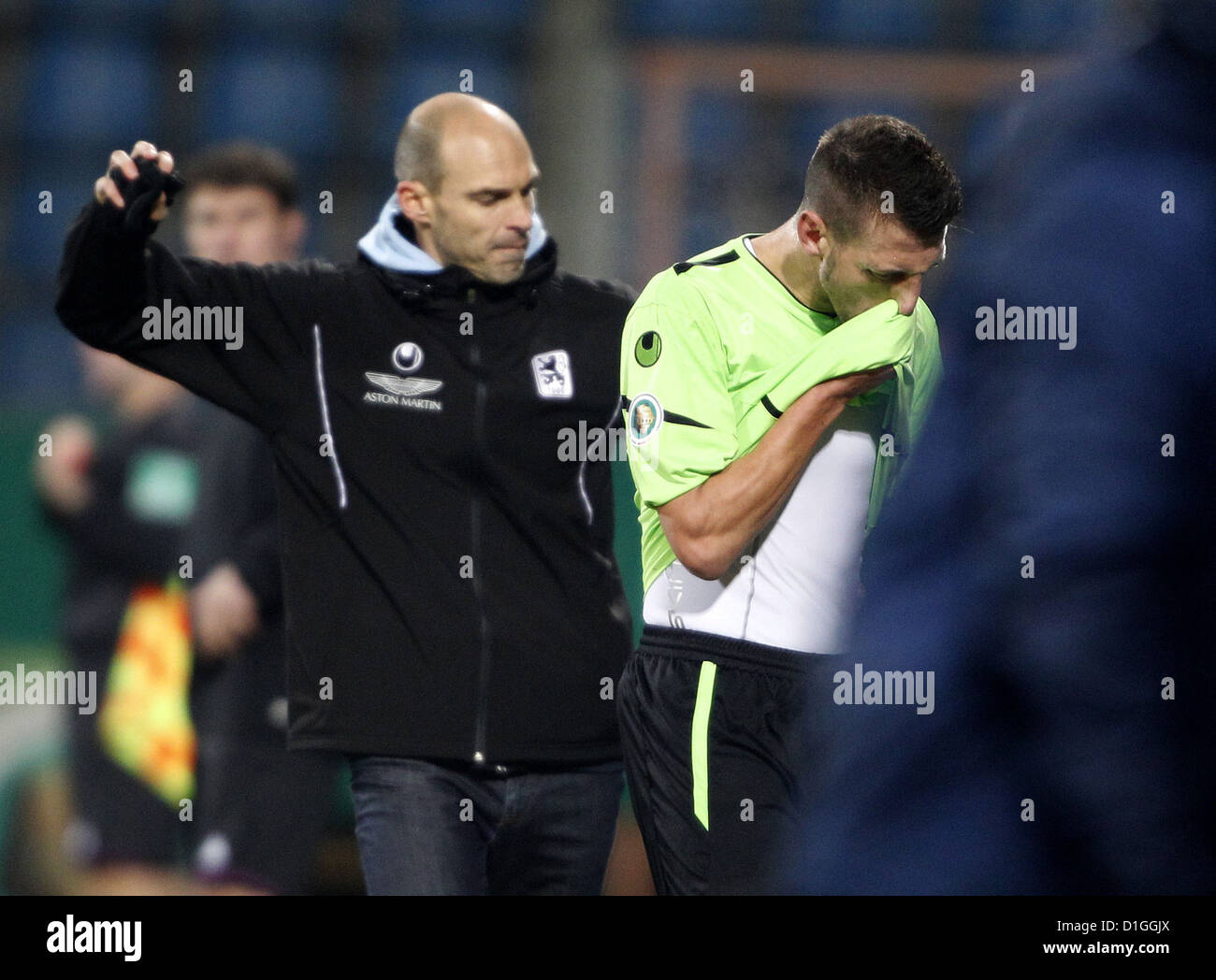 Guillermo Vallori de Munich champ feuilles après avoir vu la carte rouge alors que Munich entraîneur en chef Alexander Schmidt les gestes en arrière-plan lors de la dernière ronde de la coupe DFB 16 entre fL Bochum vs TSV Munich 1860 Stade Rewirpower à Bochum Allemagne 19 décembre 2012. Photo : ROLAND WEIHRAUCH (ATTENTION : l'utilisation de la DFB interdit la publication de photos sur internet d'autres séquentiel des médias en ligne au cours de match (y compris la mi-temps). ATTENTION : période de blocage ! L'utilisation d'autres permis DFB Publication de photos services mobiles (surtout MMS), DVB-H, DMB seulement après la fin du match.) Banque D'Images