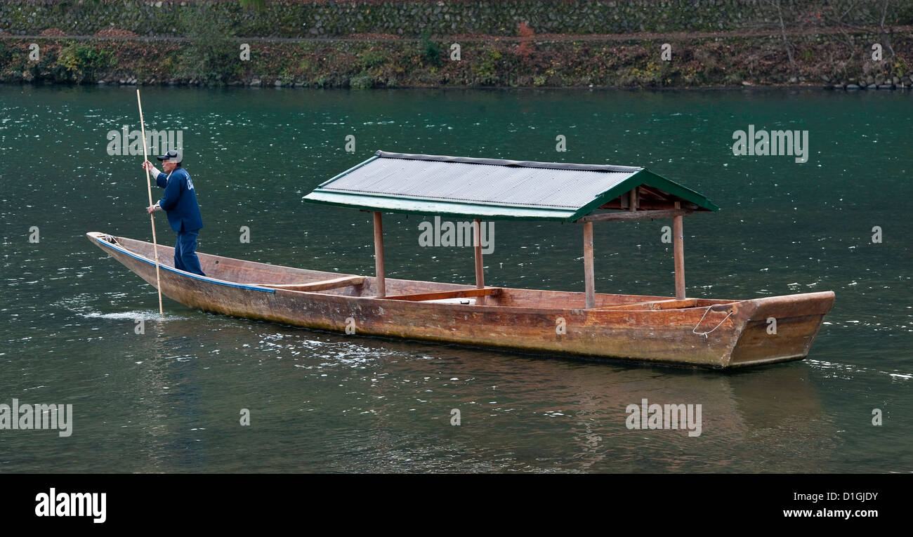 Un boatman perce son bateau le long de la rivière Katsura à Arashiyama, Kyoto, Japon Banque D'Images