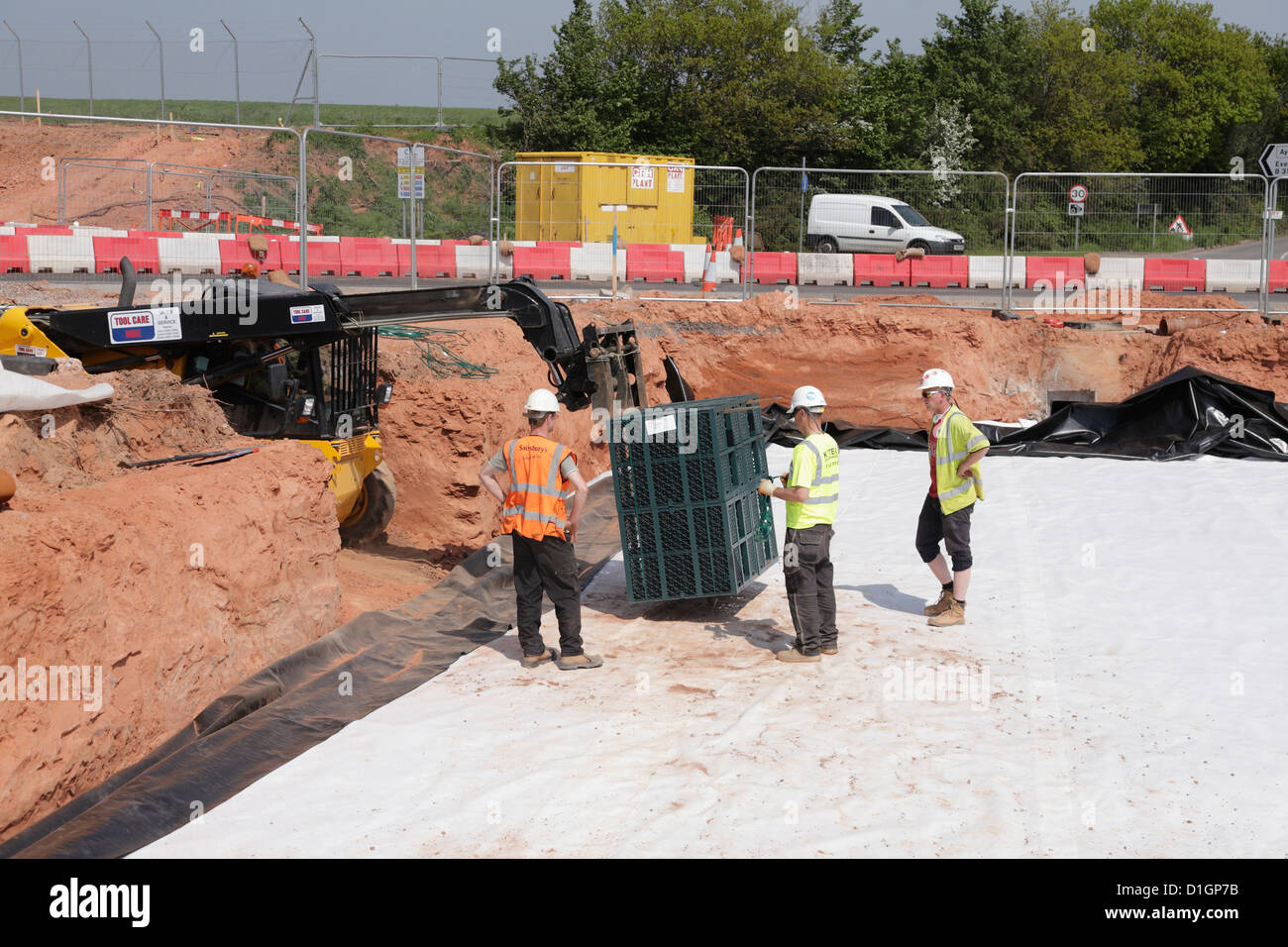 Les travailleurs du chantier durable stormbloc de drainage en plastique système de réservoir d'atténuation de la caisse sur la construction de nouvelles routes au Royaume-Uni Banque D'Images