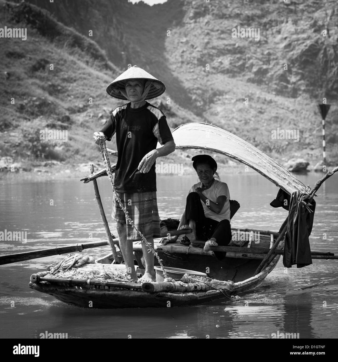 Couple dans leur bateau de pêche dans la province de Ninh Binh au Vietnam, Asie du sud-est Banque D'Images