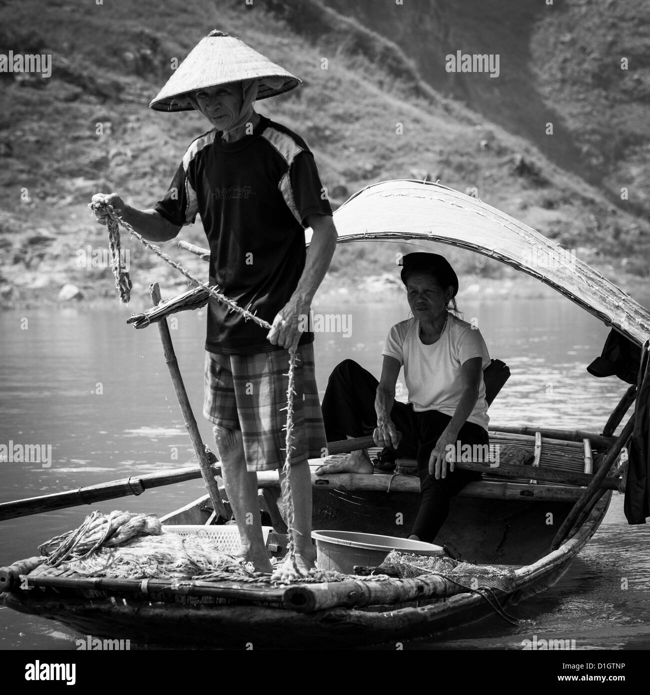 Couple dans leur bateau de pêche dans la province de Ninh Binh au Vietnam, Asie du sud-est Banque D'Images