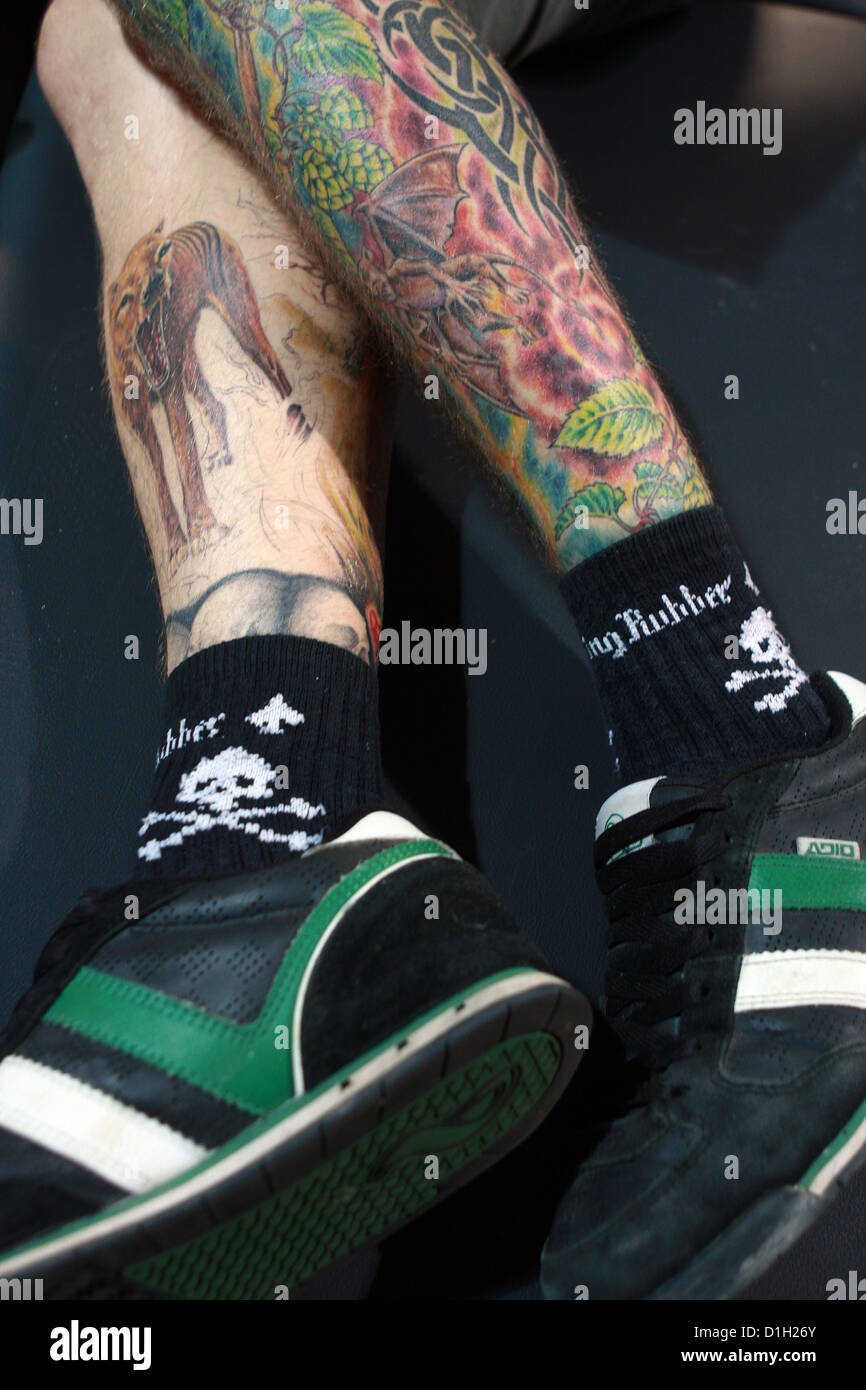 Les jambes tatouées, chaussettes et chaussures de sport Banque D'Images