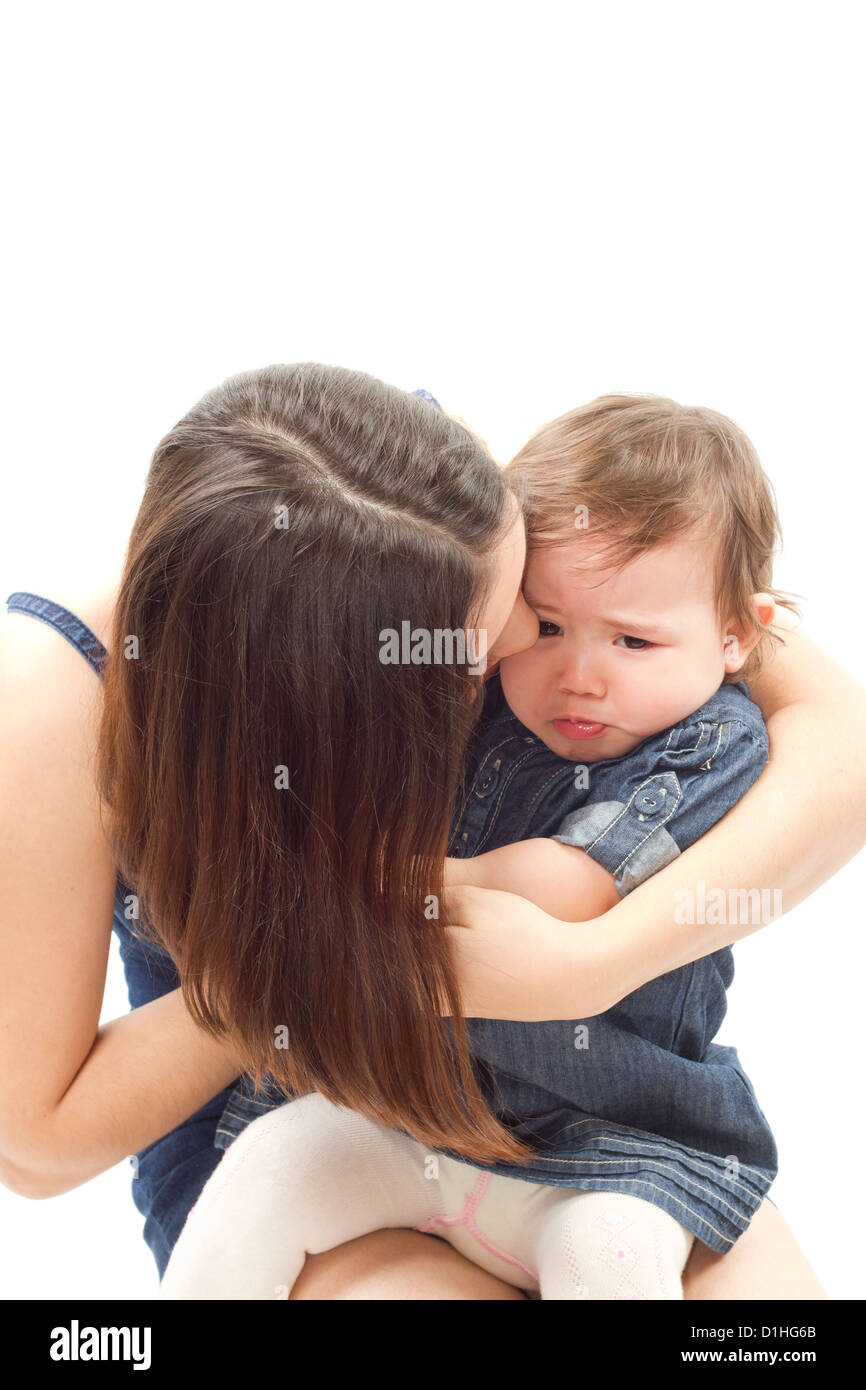 Mère apaise un bébé qui pleure fille sur un fond blanc Banque D'Images