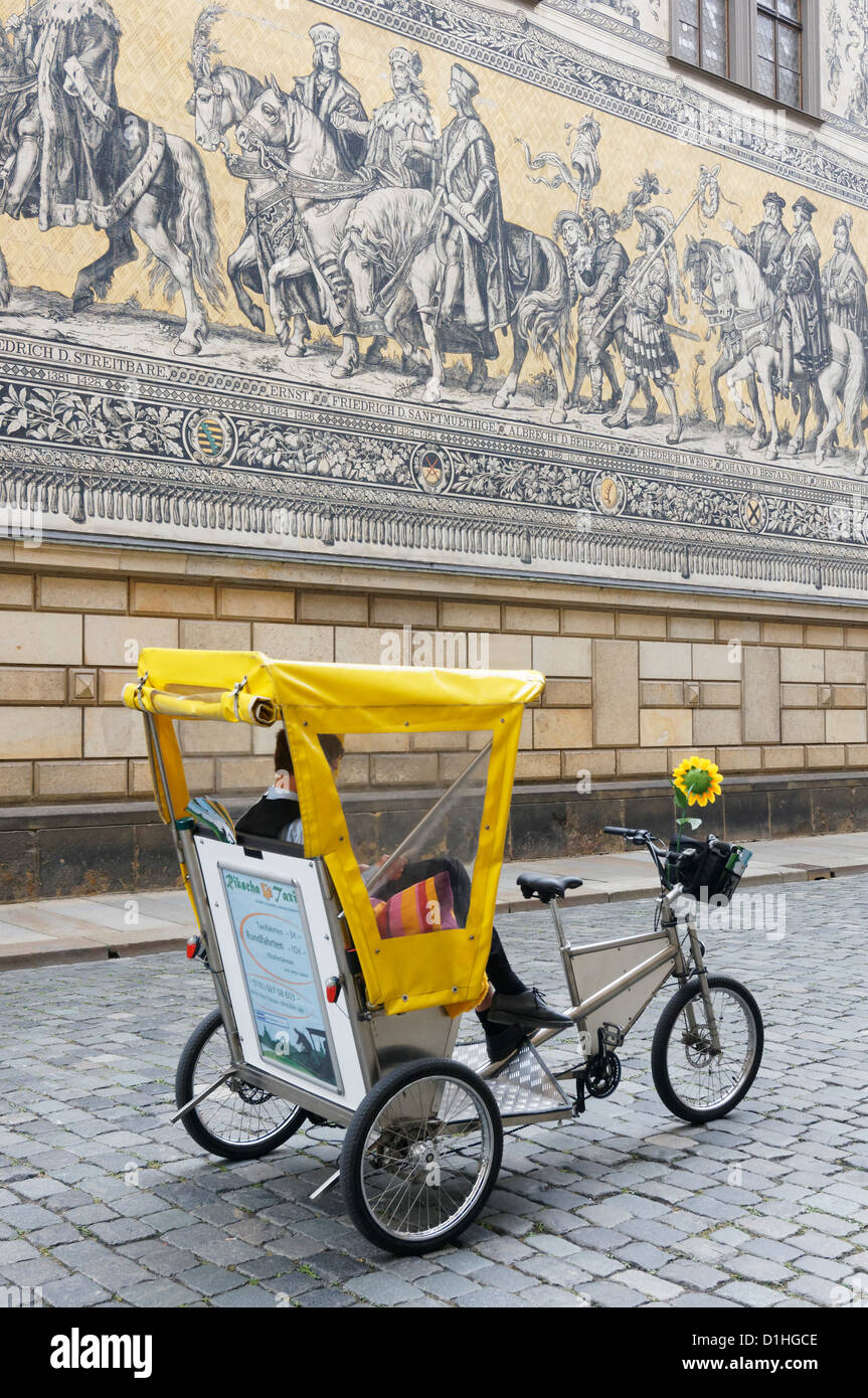 Un vélo-taxi en face de l'Furstenzug (Procession des Princes) sur Augustusstrasse, Altstadt, Dresde, Saxe, Allemagne. Banque D'Images