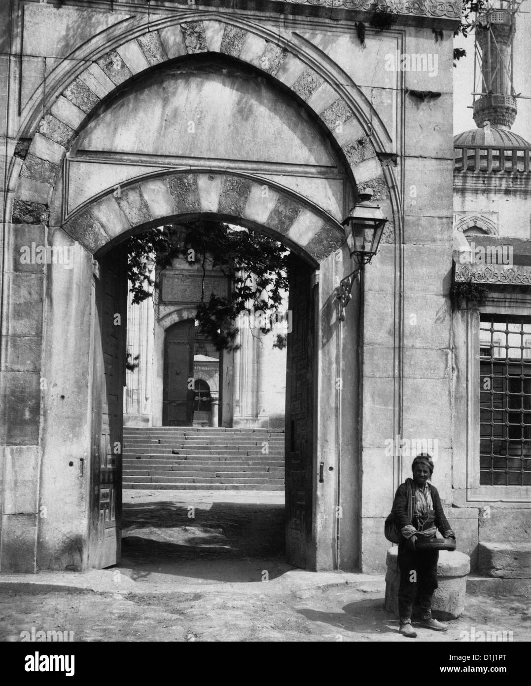 Entrée de la Mosquée Ahmed - homme debout à l'extérieur entrée de Sultanahmet Camii - Istanbul, Turquie, circa 1900 Banque D'Images