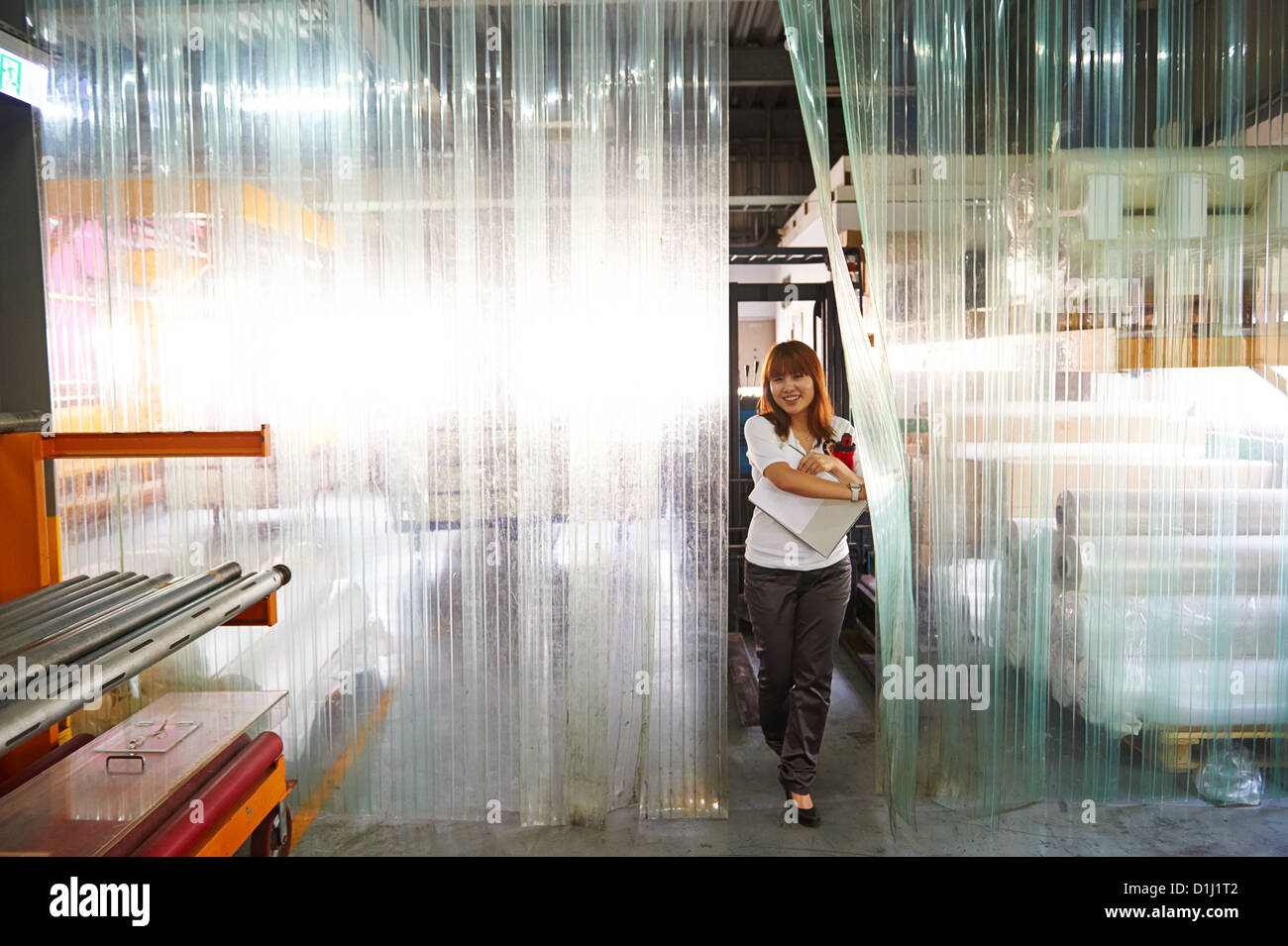 Une fille marche dans bâche en plastique dans une usine Banque D'Images