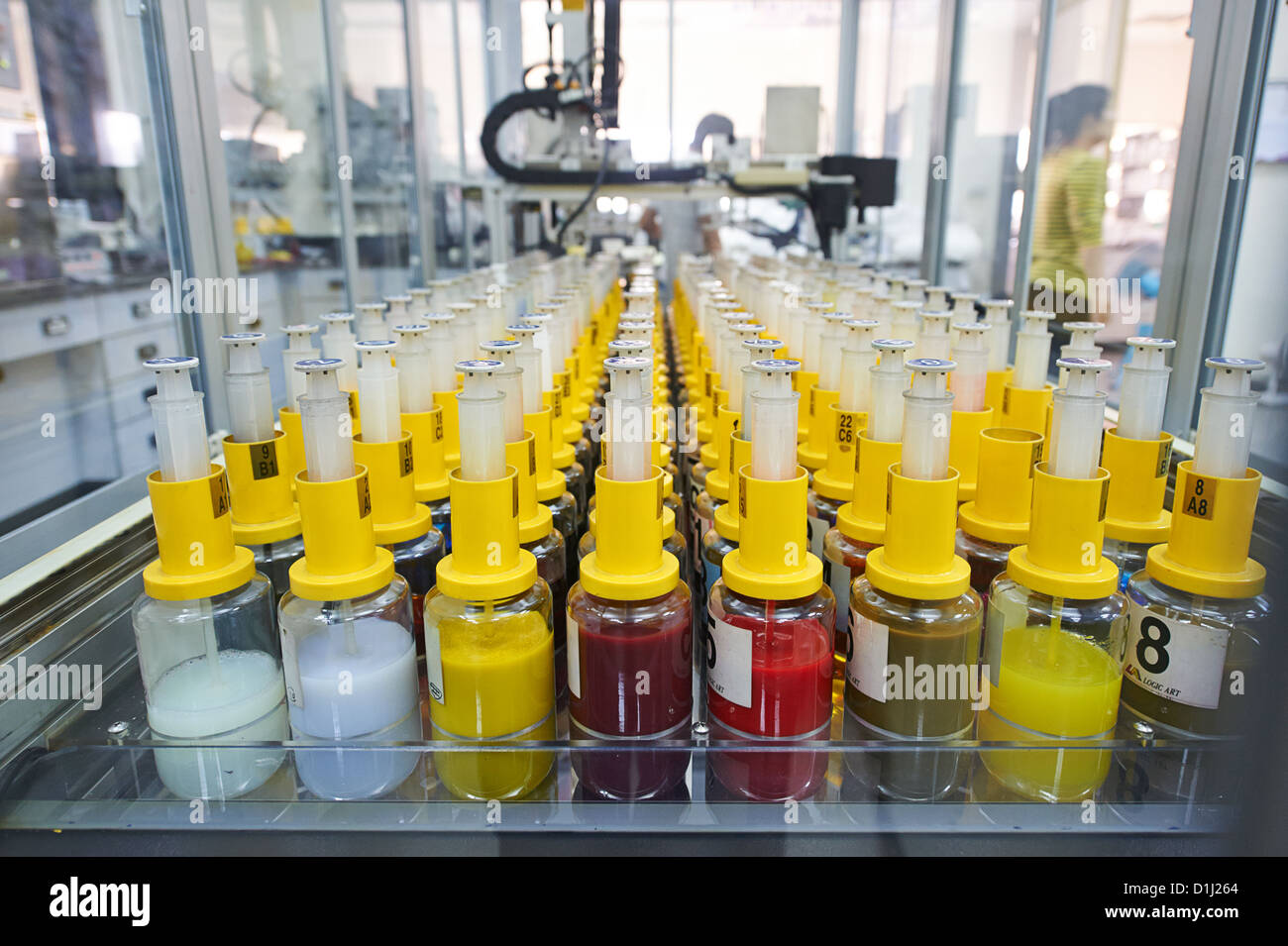 Un travailleur ajuste une machine couleur mourir à l'usine et laboratoire de recherche où l'étoffe est recherché, produits et fabriqués Banque D'Images