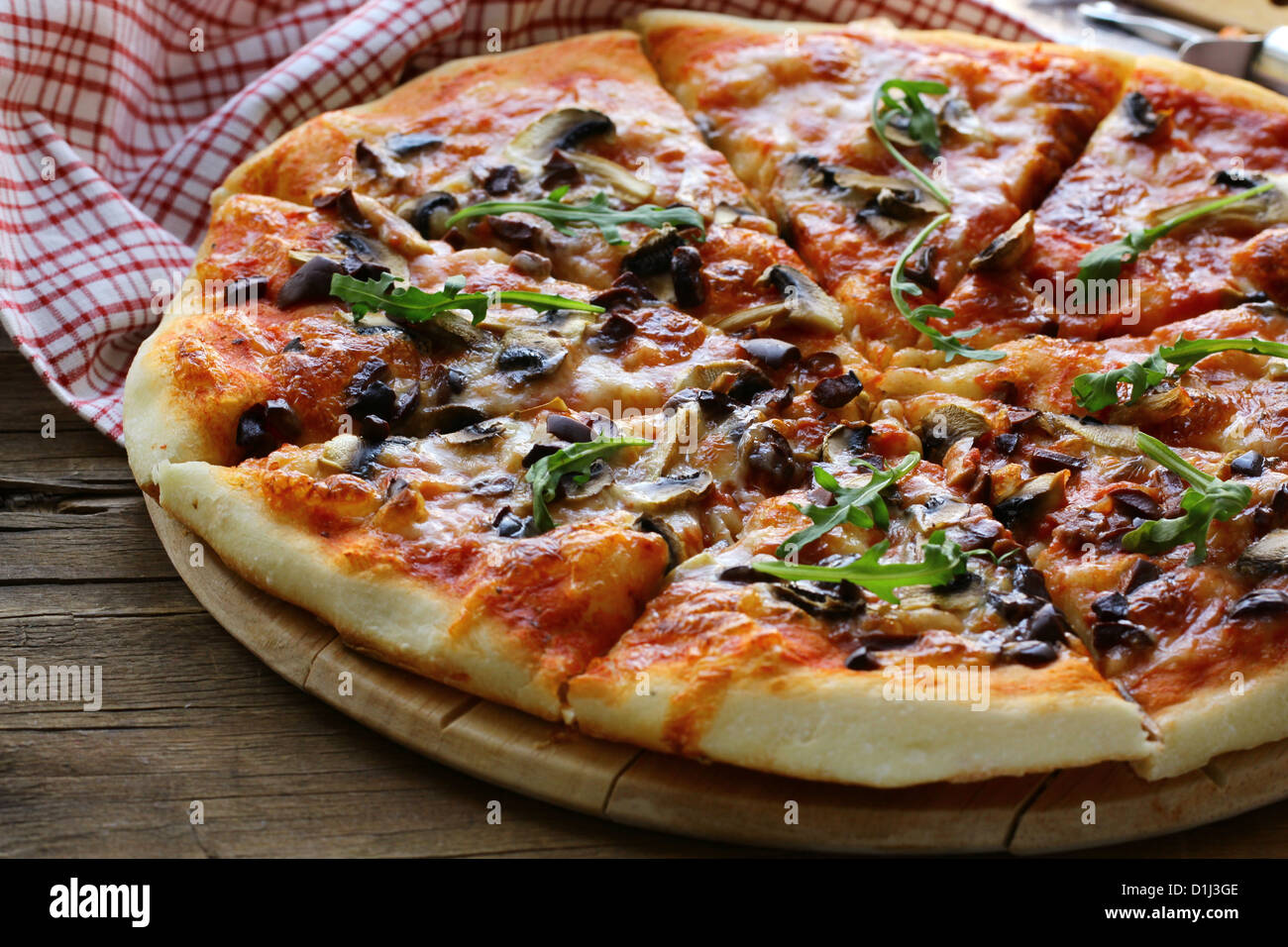 Pizza italienne avec des champignons et des olives sur une planche en bois Banque D'Images