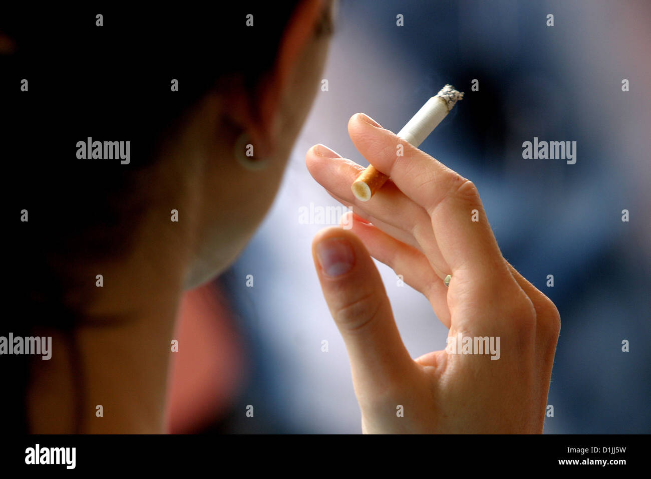 Femme fumant de la cigarette, vue arrière pour tenir la cigarette à la main Banque D'Images