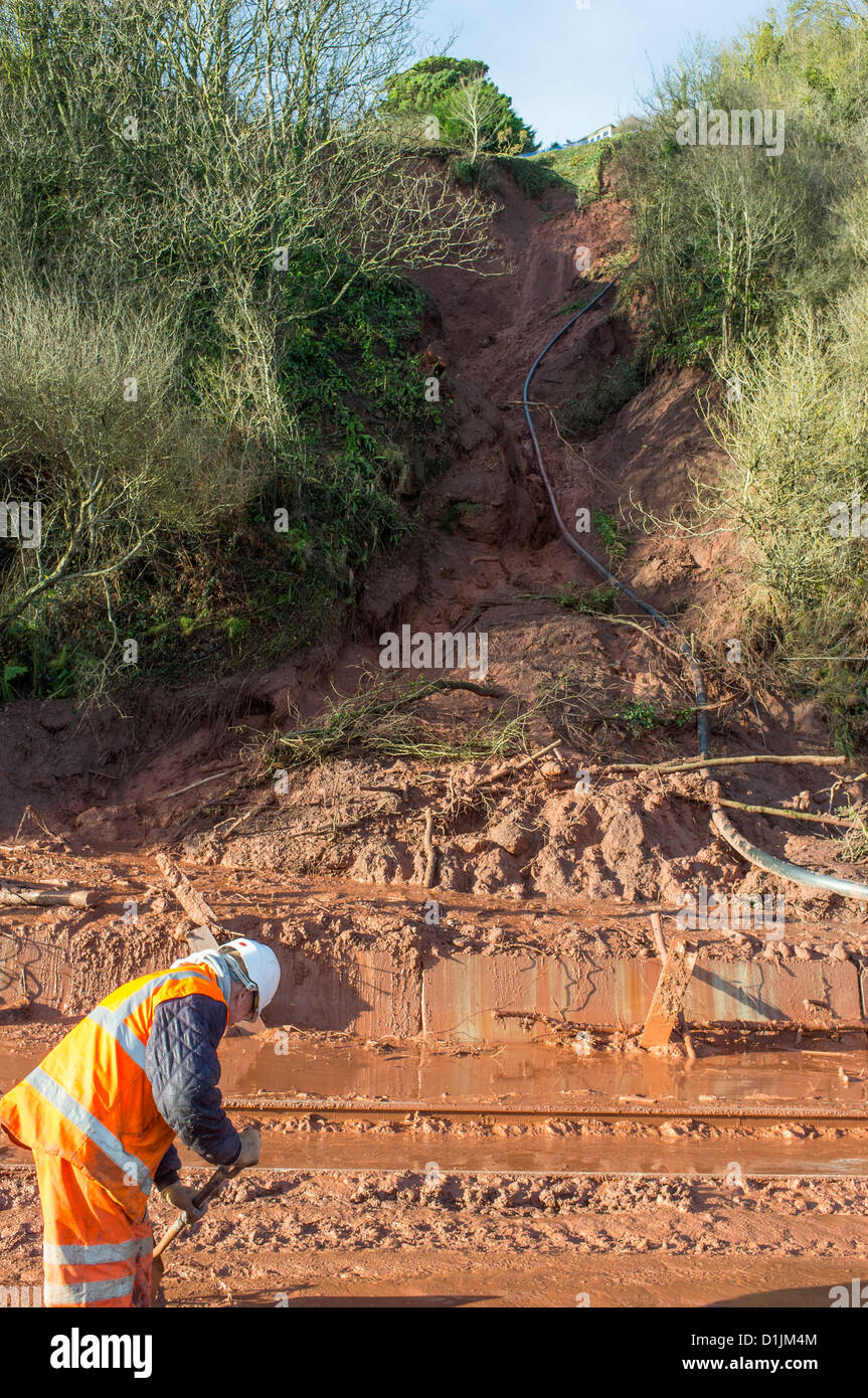 Teignmouth, Devon, Angleterre. 24 décembre 2012. Un glissement de terrain au Teignmouth à Exmouth ligne de chemin de fer avec un chemin de fer workman. Banque D'Images