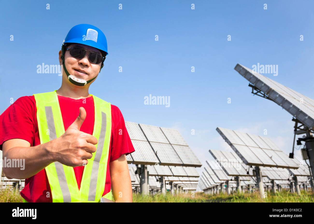 Travailleur heureux avec pouce vers le haut et l'article avant de panneau solaire Système de suivi Banque D'Images