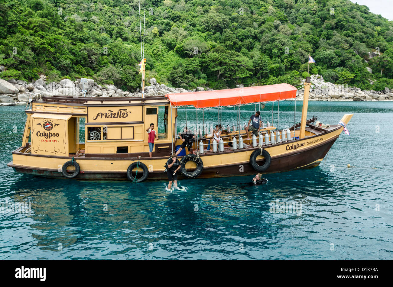 Plongeur femelle saute bateau de plongée dans l'eau à la baie par Ko Tao dans le golfe de Thaïlande Banque D'Images