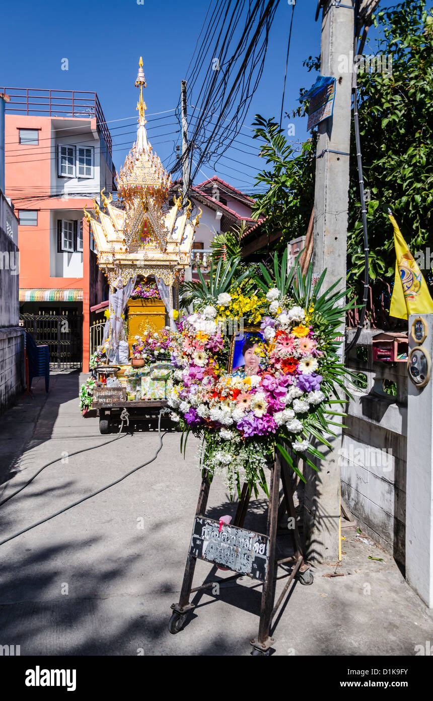 Photo de défunte encadrée de fleurs avec de grandes funérailles bouddhistes richement décorées tenant son flotteur corps en Thaïlande Banque D'Images