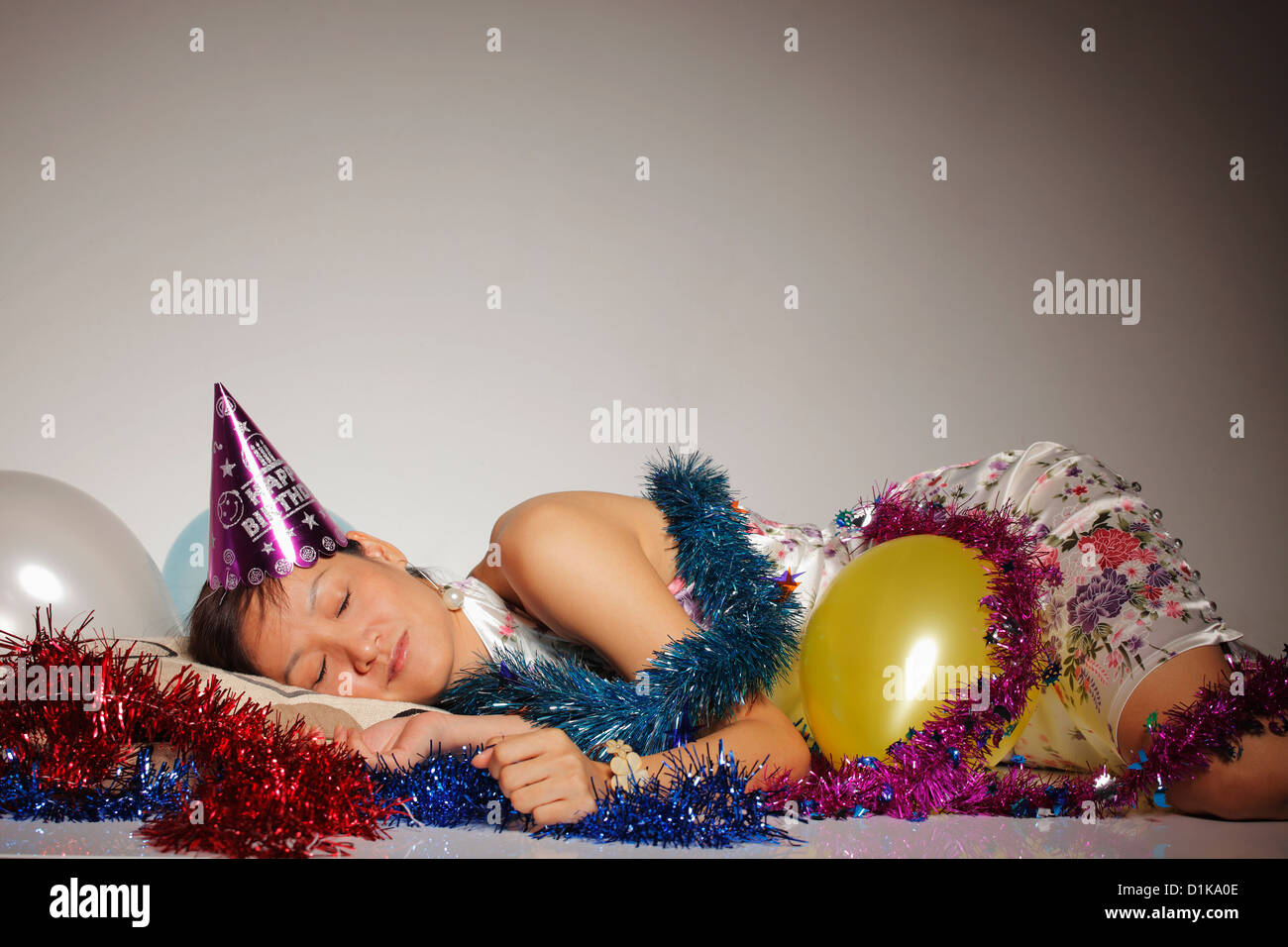 Femme endormie entre les ballons et banderoles parti Banque D'Images
