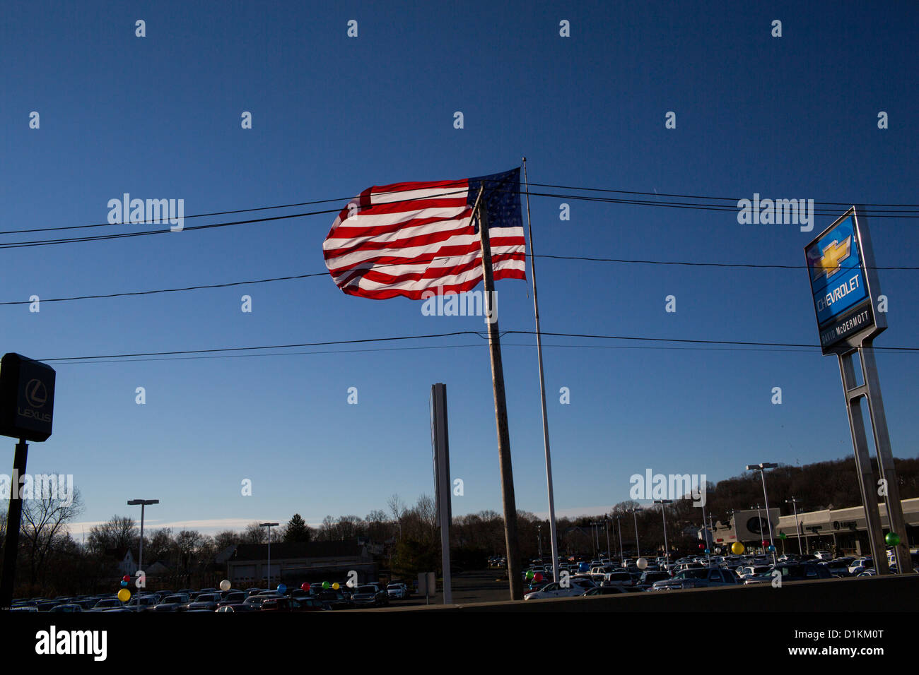 Un grand drapeau américain vole au-dessus d'un Chevrolet location terrain du concessionnaire dans la région de East Haven, Connecticut. Banque D'Images