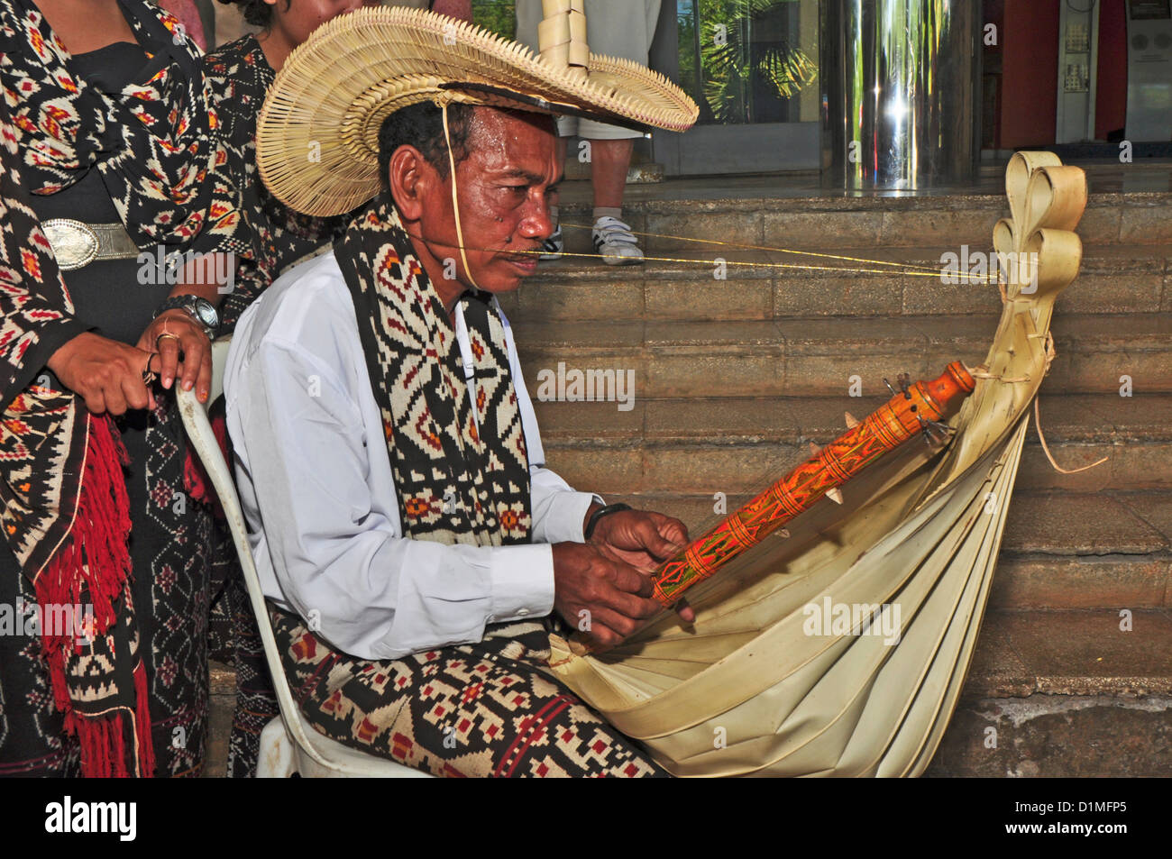 L'Indonésie, Timor Occidental, à Kupang, musicien, avec des danseuses en costume traditionnel, jouant un instrument de musique (sasando fait fr Banque D'Images