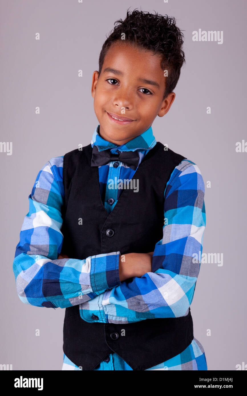 Portrait d'un mignon petit garçon afro-américain, les bras croisés, isolé sur fond blanc Banque D'Images