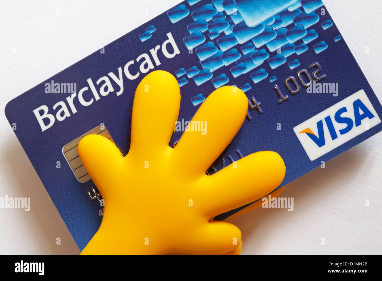 Mains jaunes tenant Barclaycard Visa carte de crédit sur fond blanc - tenant à l'argent concept s'occuper, dans le contrôle des dépenses Banque D'Images