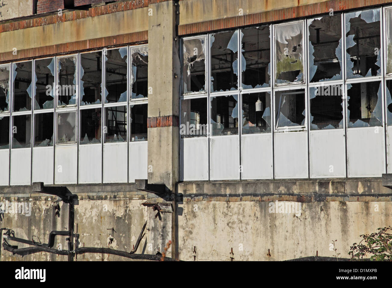 Ligne de brisé des fenêtres dans un bâtiment industriel abandonné UK Banque D'Images