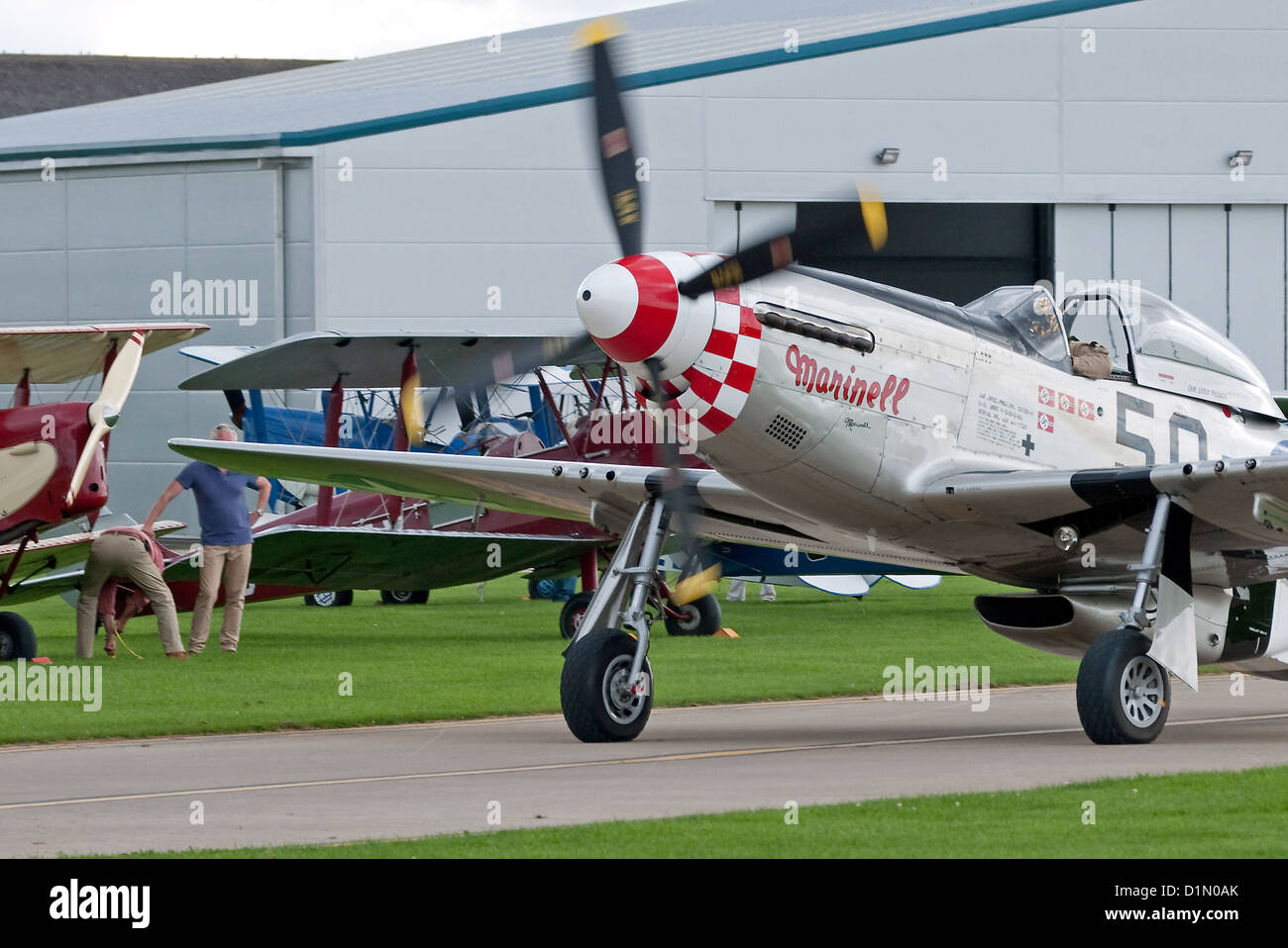 Merveilleusement entretenus P-51 Mustang fighter en taxis passé une ligne d'aéronefs d'époque à l'Air Show 2012 Sywell Banque D'Images