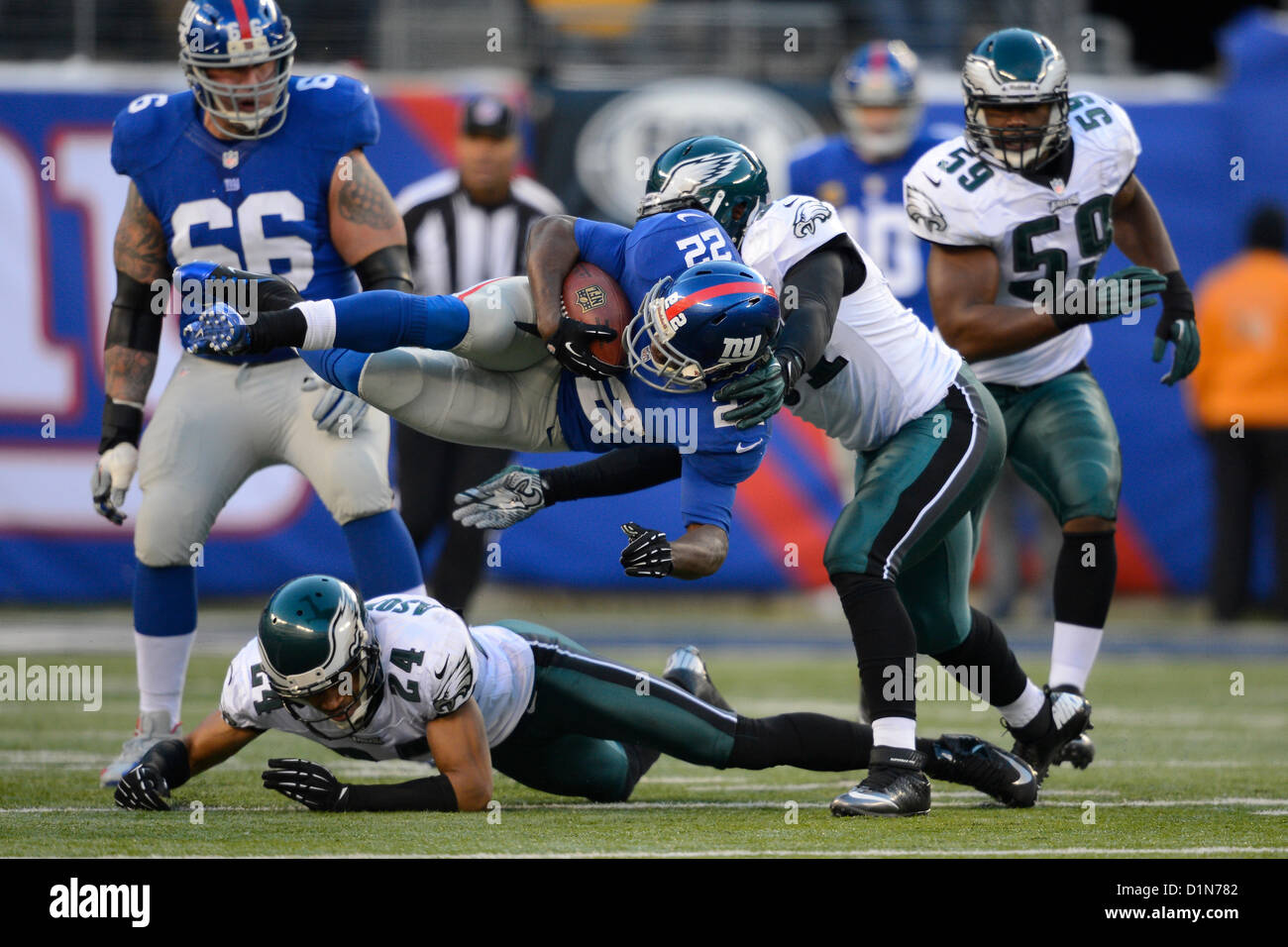 New Jersey, USA. 30 Décembre 2012 : Nouvelle York énorme tournant retour David Wilson (22) s'exécute avec la balle dans Philadelphia Eagles Nnamdi évoluait Motaze (24) et Philadelphia Eagles en dehors de linebacker Jamar Chaney (51) pendant une semaine 17 du duel entre la NFL Philadelphia Eagles et les Giants de New York au Stade MetLife à East Rutherford, New Jersey. Les Géants a vaincu les Eagles 42-7. Banque D'Images