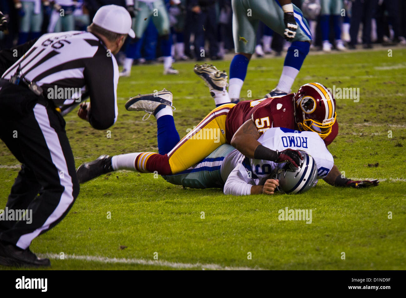 Perry Riley, secondeur Redskins, s'attaque à Tony Romo, quart-arrière des cowboys, après avoir lancer la balle pendant la Redskins de Washington et Dallas Cowboys jeu au FedEx Field à Landover, Maryland, 30 décembre 2012. Lors d'une pause commerciale, les troupes ont été honorés lors de la partie par USAA devant plus de 82 000 fans. Les Redskins a gagné 28-18 à l'avance dans les séries éliminatoires. (U.S. Photo de l'armée) Banque D'Images