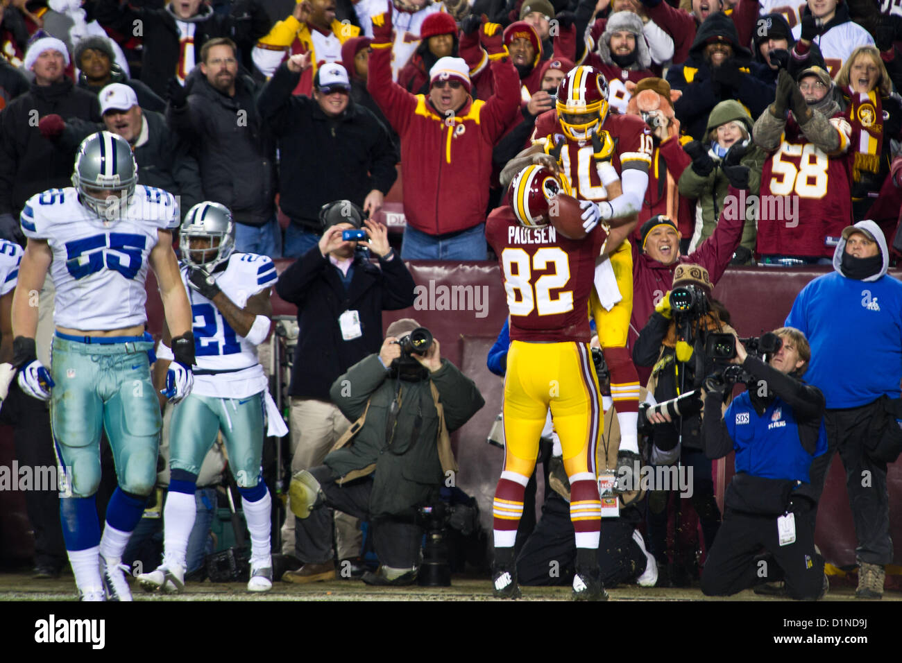 Le quarterback des Redskins de Washington Robert Griffin III est relevé par son coéquipier Logan Paulsen après un touchdown de troisième quart-temps lors du match NFL contre les Cowboys de Dallas au FedEx Field à Landover, Maryland, le 30 décembre 2012. Les Redskins ont gagné 28-18, avançant aux séries éliminatoires. L'USAA a honoré les troupes lors d'une pause commerciale devant plus de 82 000 fans. Banque D'Images