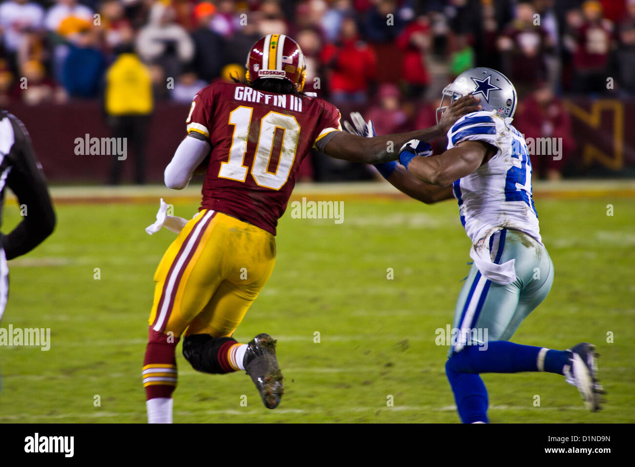 Robert Griffin III armoiries un défenseur des Dallas Cowboys lors d'une course de 17 yards au match des Washington Redskins vs Dallas Cowboys à FedEx Field le 30 décembre 2012. Banque D'Images