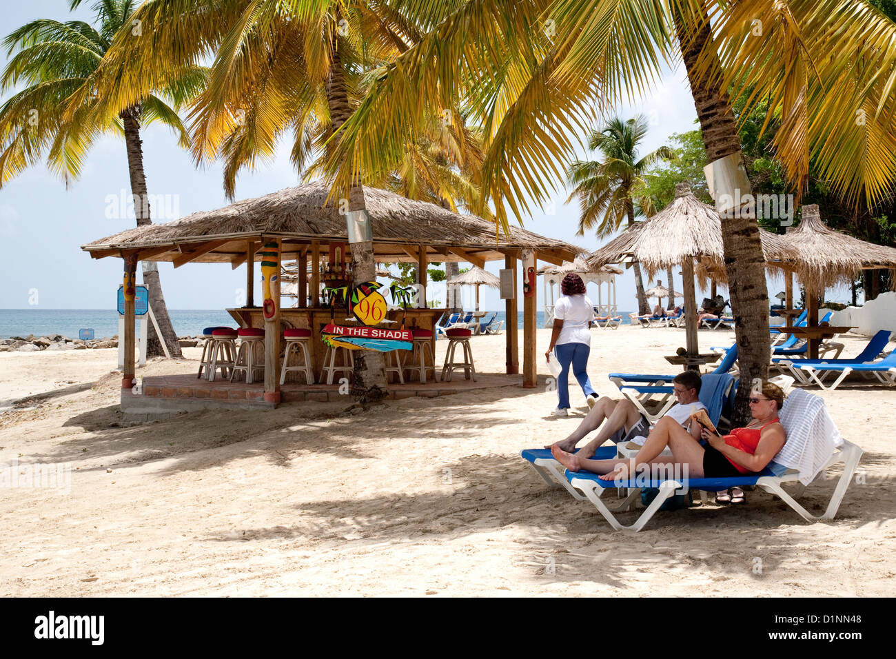 Les gens à prendre le soleil sur la plage par le bar, le Windjammer Landing, Sainte-Lucie, Caraïbes Antilles Banque D'Images